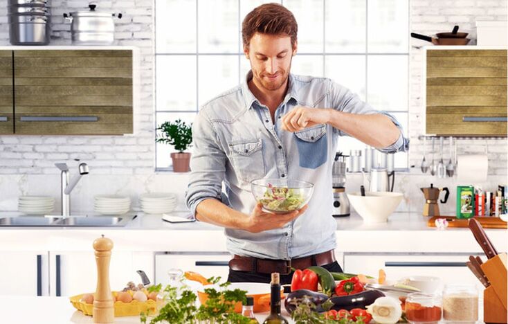 hombre prepara ensalada de verduras para aumentar la potencia